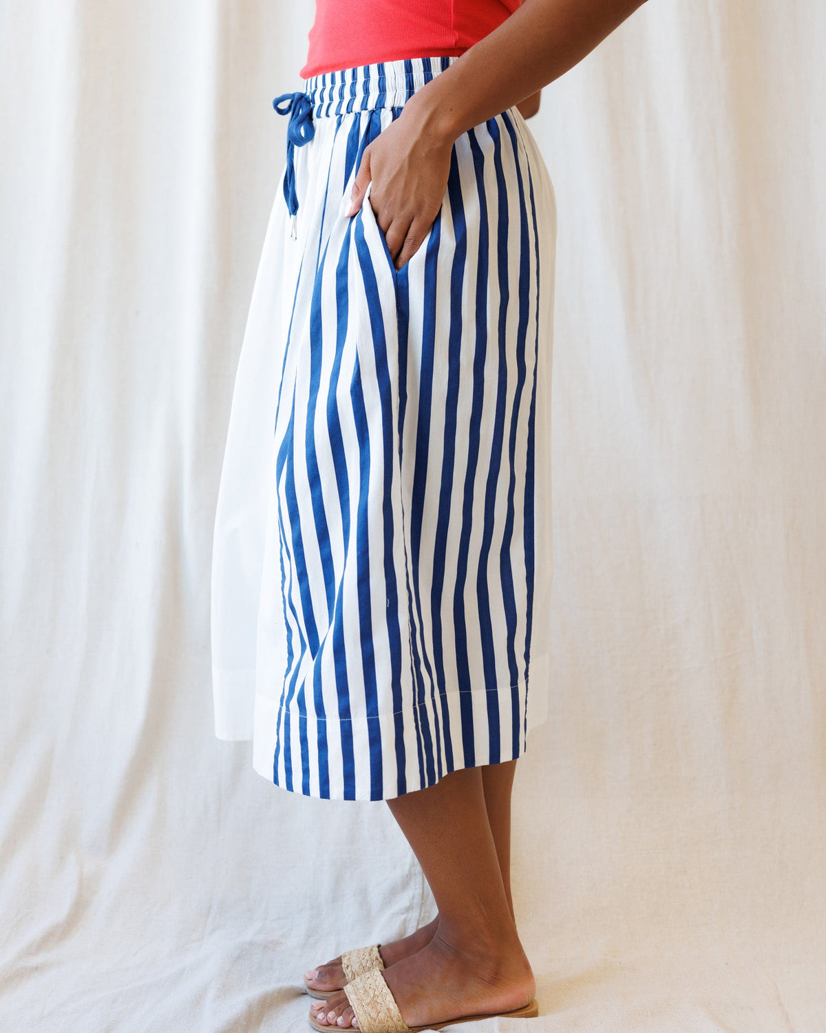 Person wearing blue and white striped pants against a white background