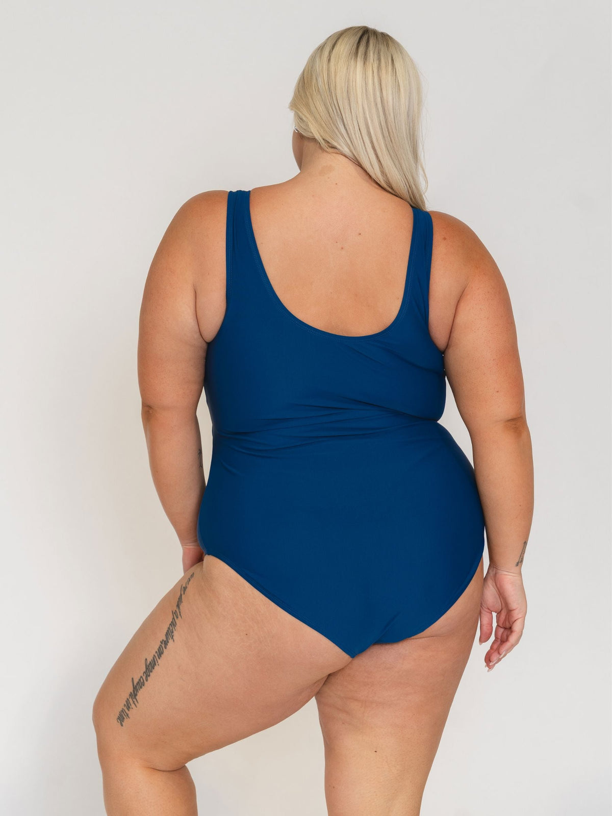 Person wearing a blue swimsuit against a white background
