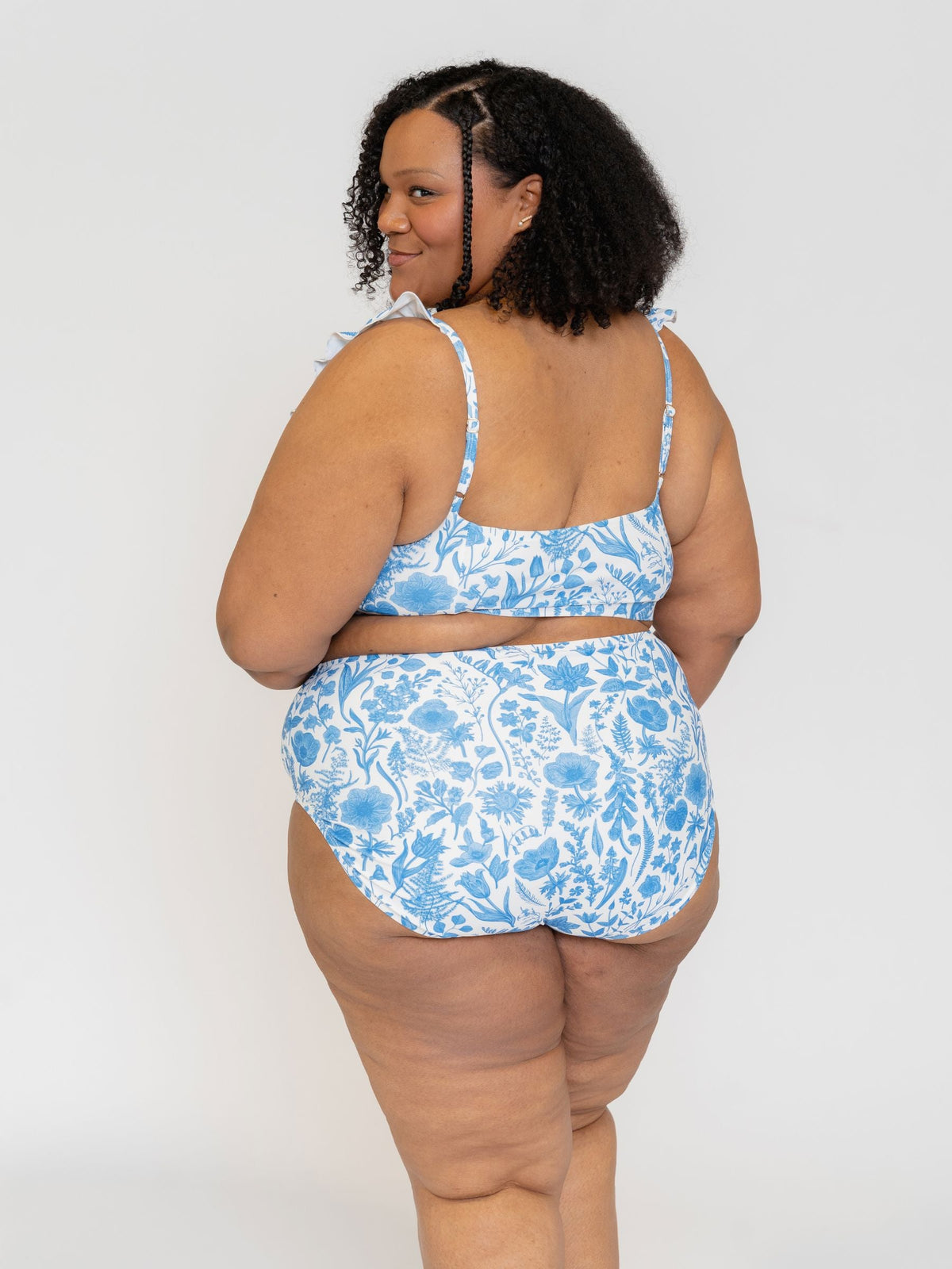 Woman wearing a blue floral bikini set on a white background