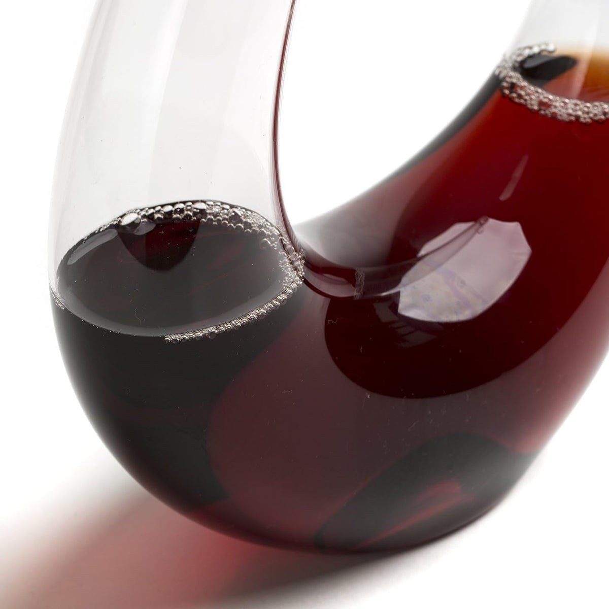 Close-up of a glass filled with red wine on a white background