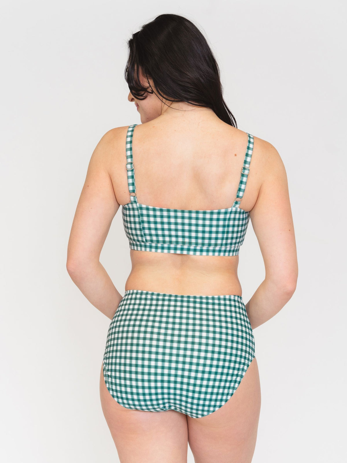 Woman wearing a green checkered bikini set on a white background