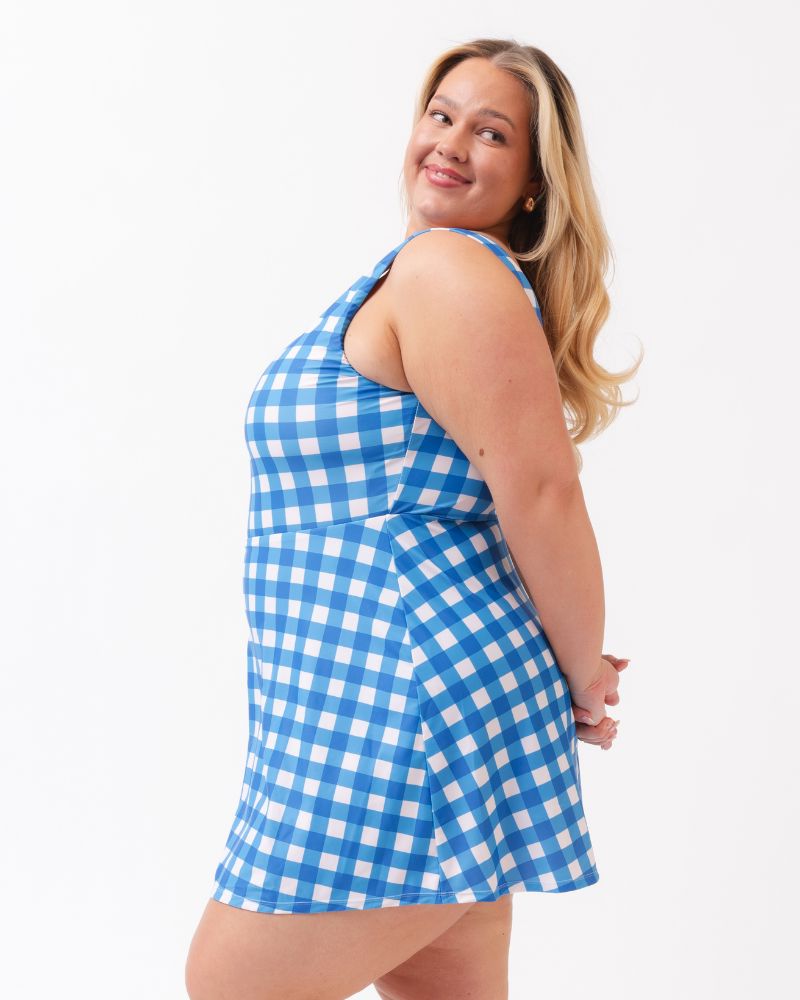 Woman wearing a blue and white checkered dress on a white background