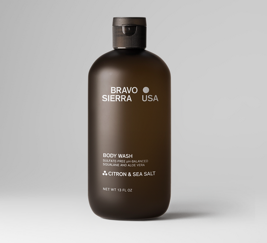 A 13 fl oz bottle of Oris & Santal Body Wash by Bravo Sierra, featuring a dark brown translucent bottle and a black cap, set against a clean white background.