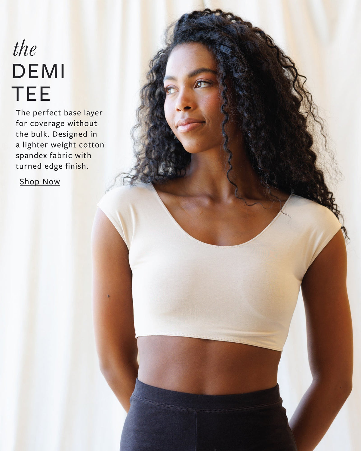 Woman wearing a beige crop top with text about the DEMI TEE product.