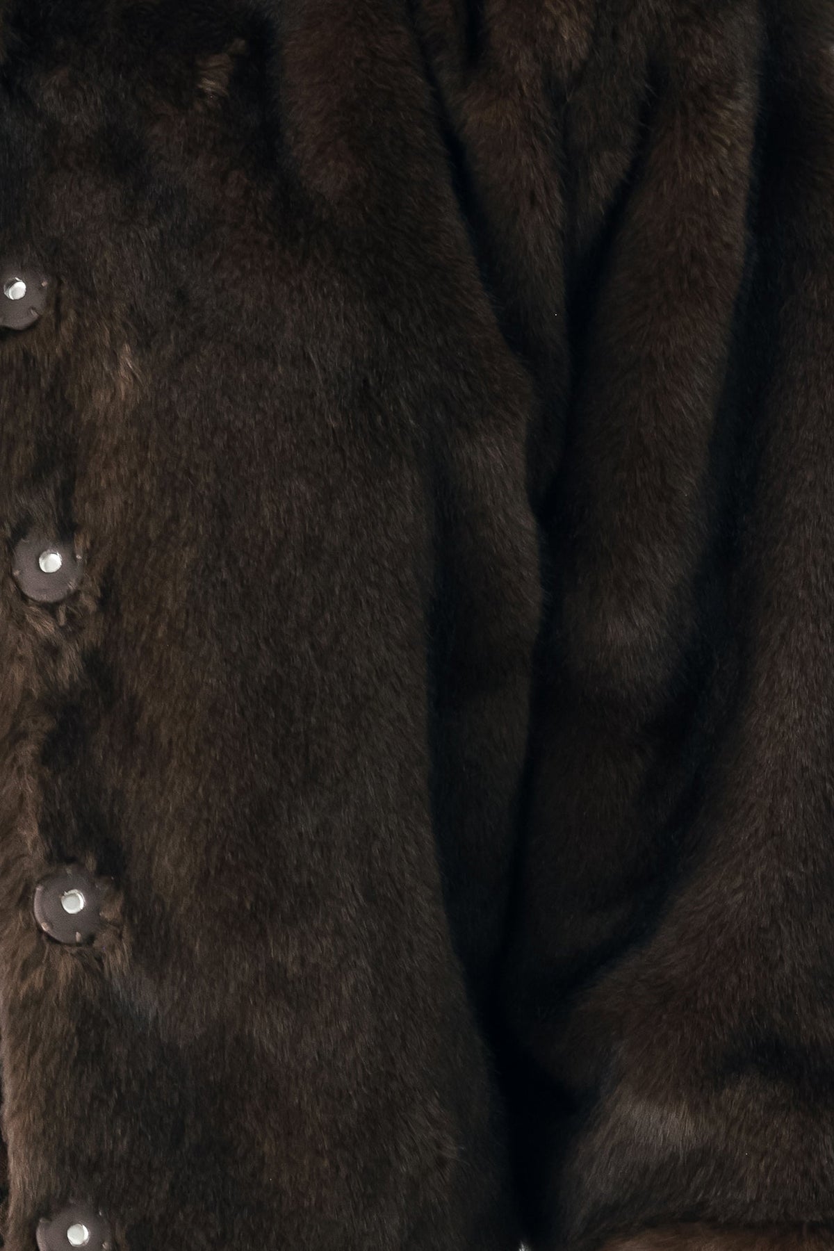 Close-up of a dark brown fur garment with visible button details along the side.