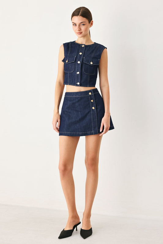 Model wearing the cropped indigo denim vest with the matching indigo denim skort.