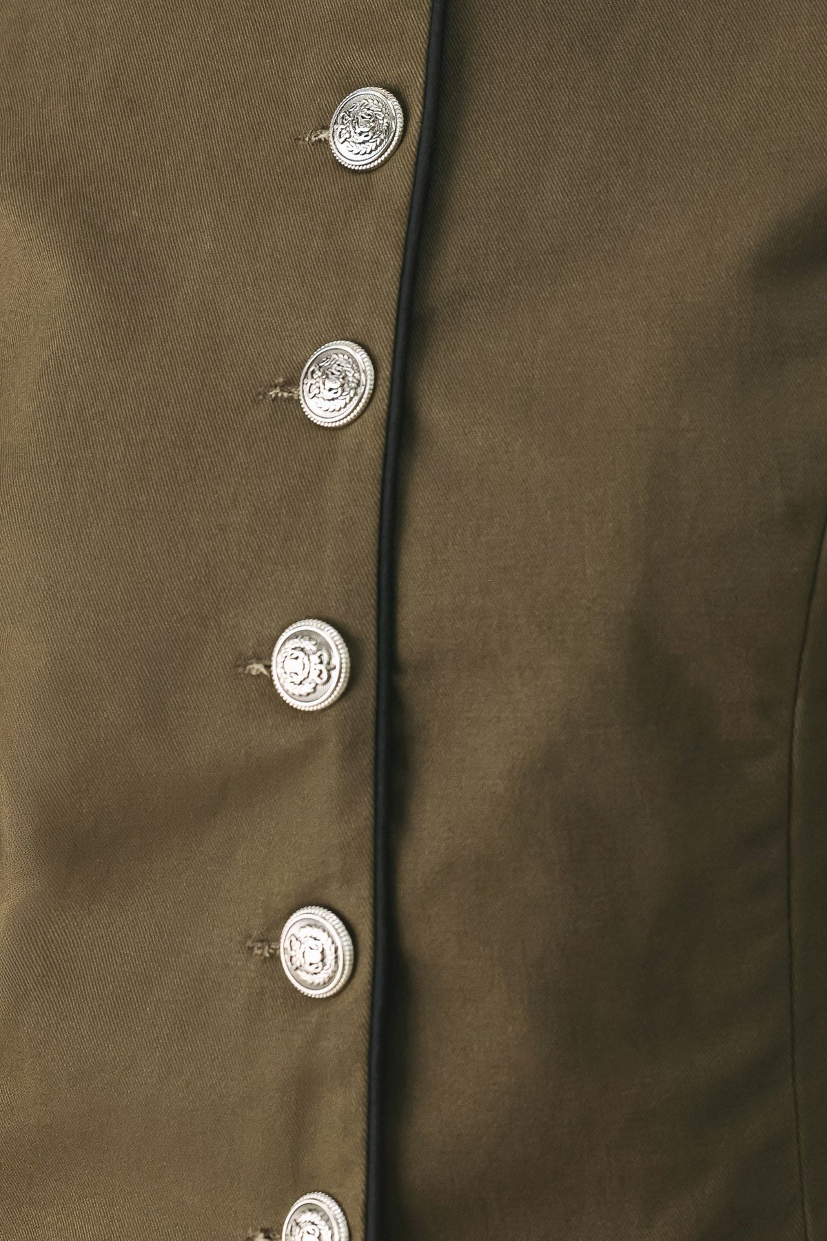 Fabric swatch showing the 100% cotton olive woven fabric of the Olive Cadet crop jacket.