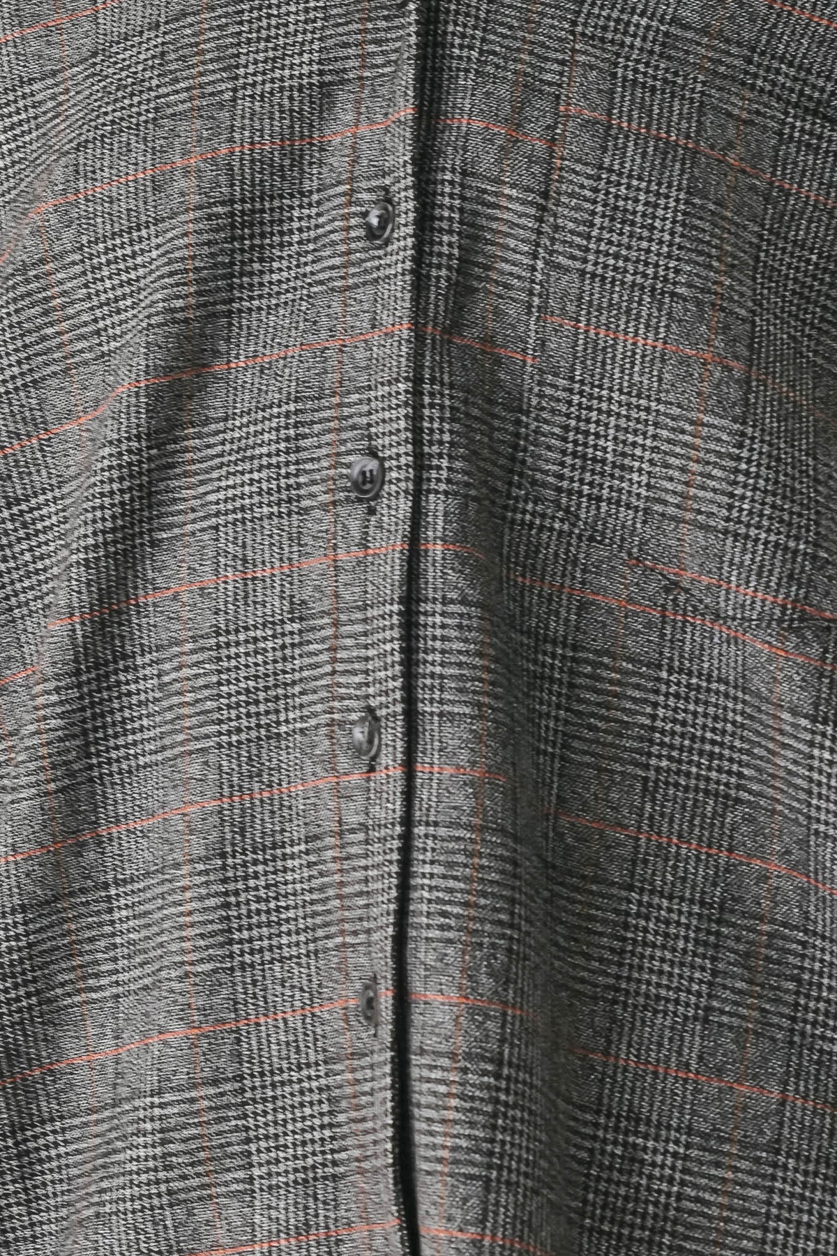 Close-up of a gray plaid button-up shirt fabric with a thin orange windowpane check pattern.