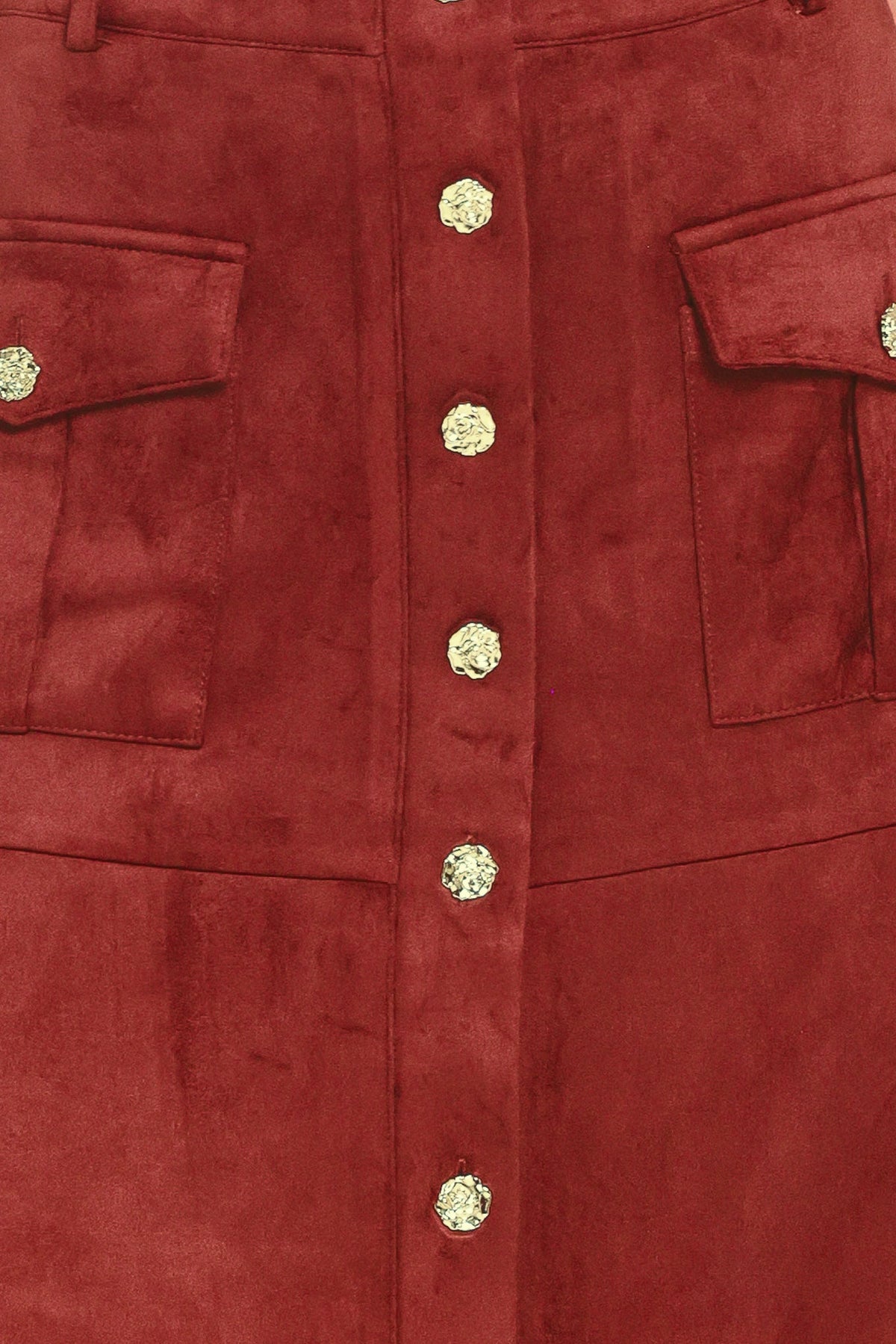 A close-up of a red suede jacket featuring a central button closure with textured gold buttons and two flap pockets on the sides.