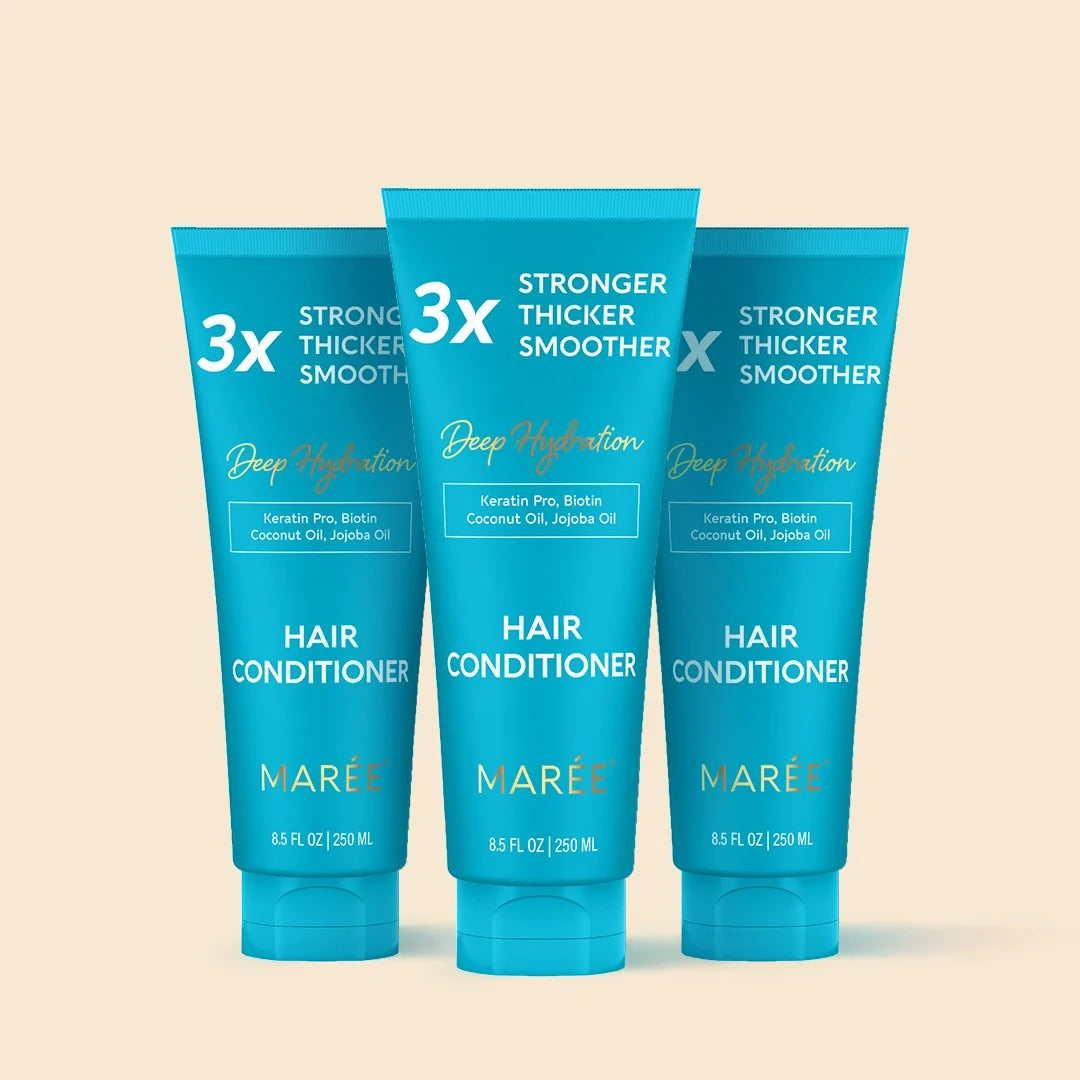 Three blue tubes of Marée hair conditioner on a beige background