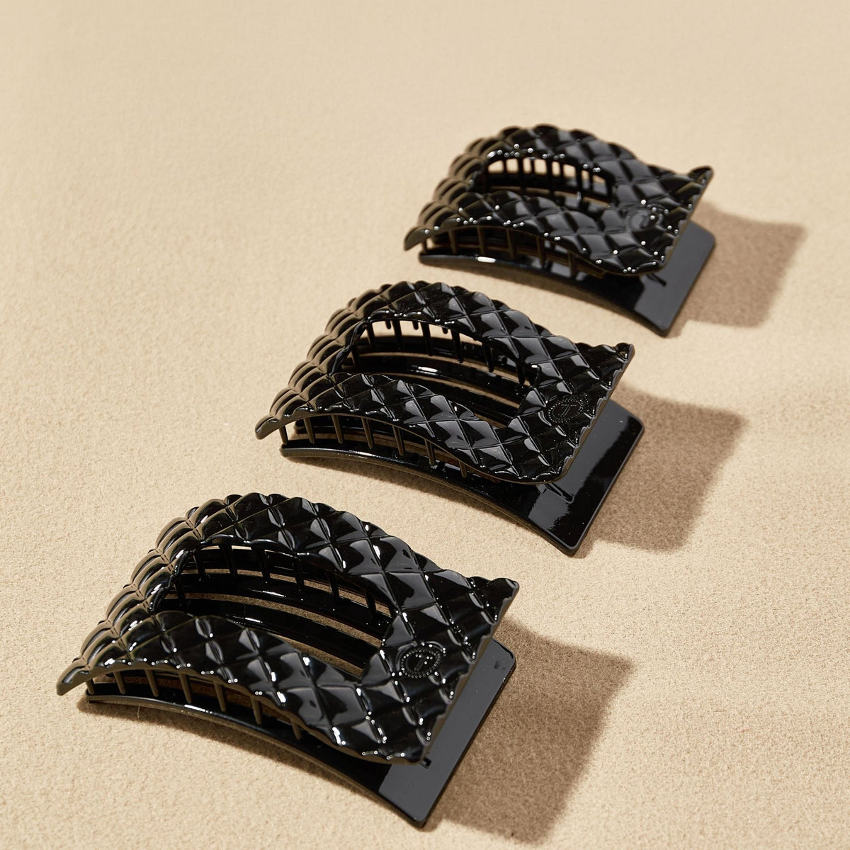 Set of black hair clips on a beige background
