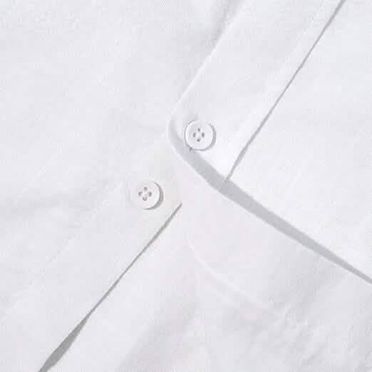 Close-up of a white shirt with button details on a light gray background