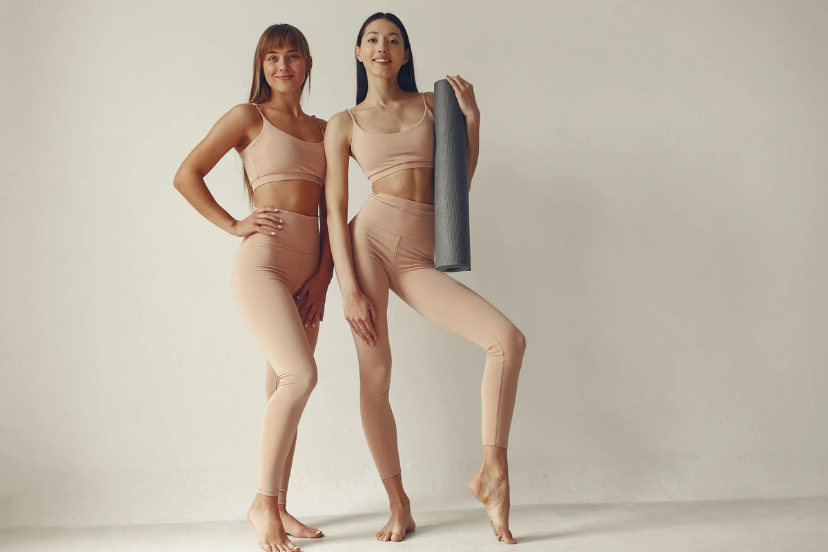 Two women's wearing activewear on white background.