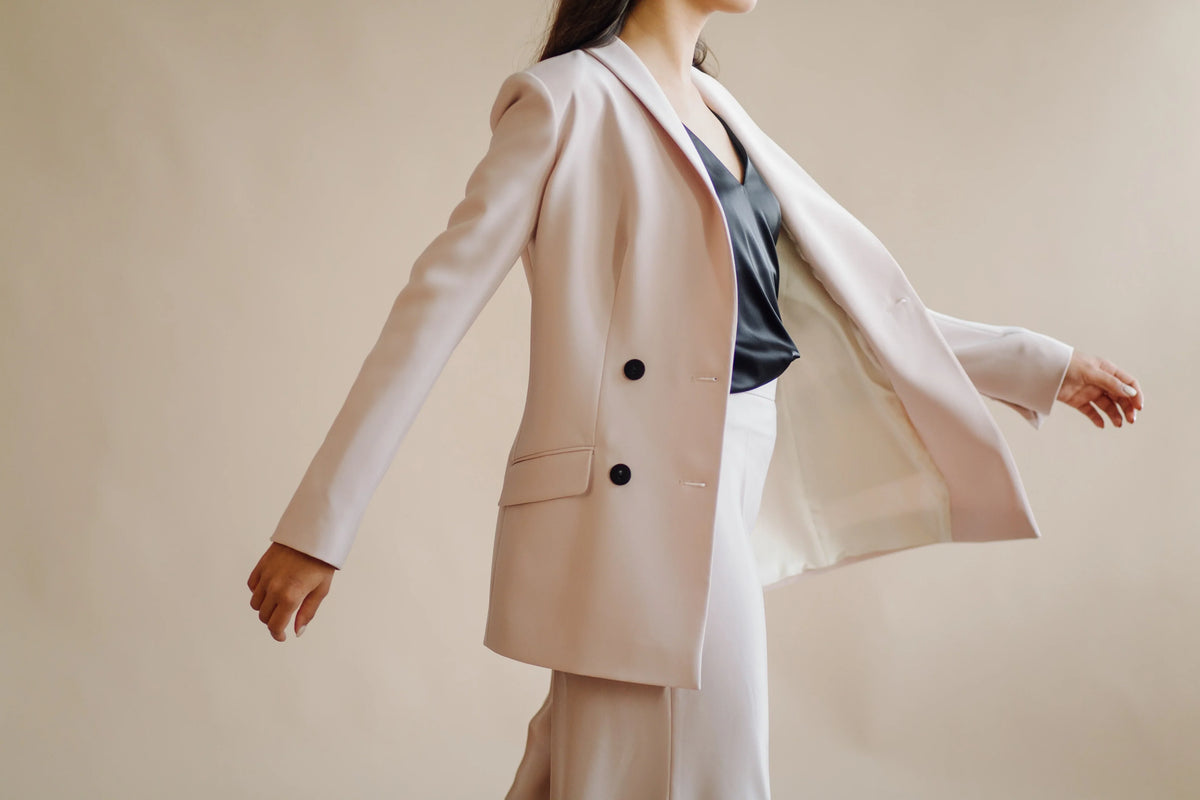 a women wearing jacket on beige background.