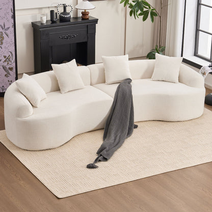 White sofa with white cushions and a gray blanket in a living room setting.