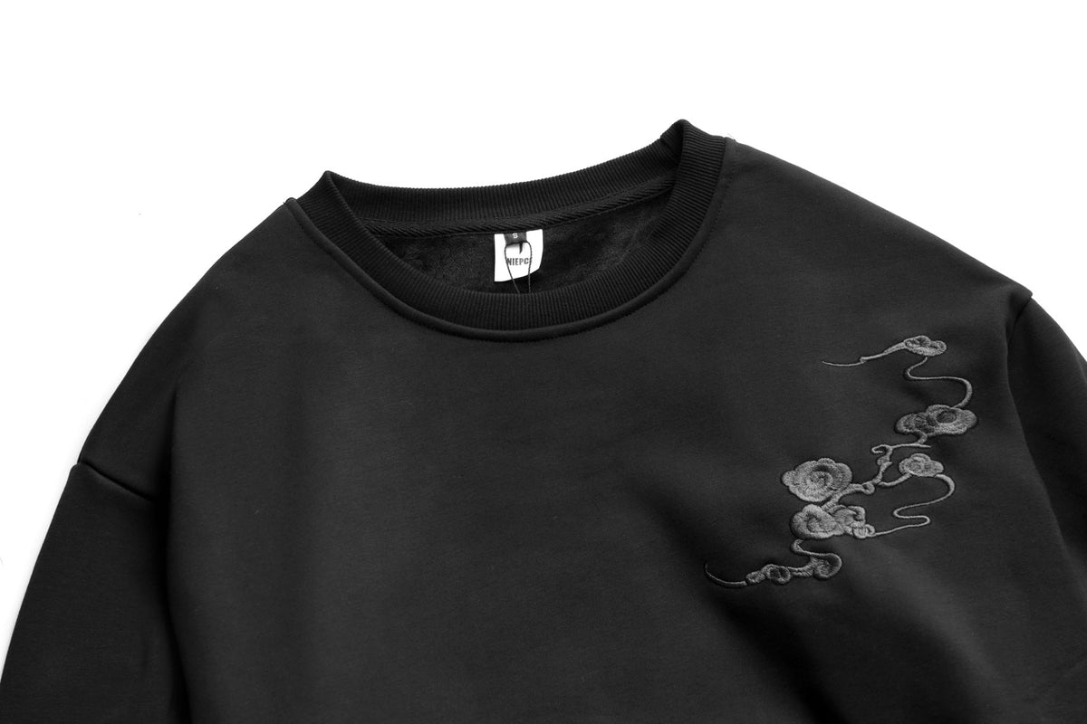 Black sweatshirt with embroidered design on a white background