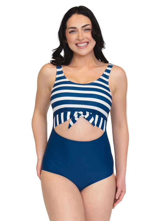 A woman modeling a one-piece swimsuit with a navy blue and white horizontally striped bodice and solid navy blue high-waisted bottoms, set against a plain white background.