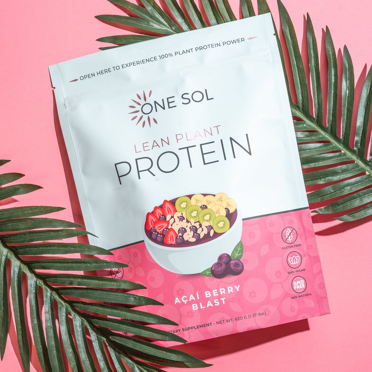 One Sol Lean Plant Protein package with acai berry blast flavor on a pink background with green leaves.