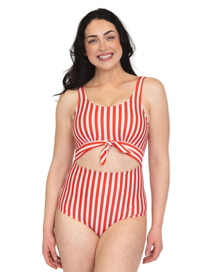 A woman modeling a red and white vertically striped one-piece swimsuit with a tie-front detail, set against a plain white background.