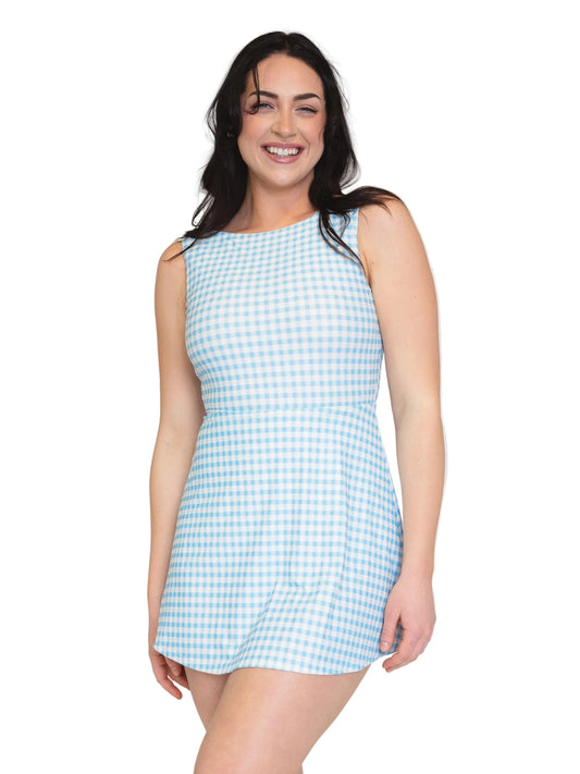 A woman modeling a sleeveless light blue and white gingham mini dress against a plain white background.