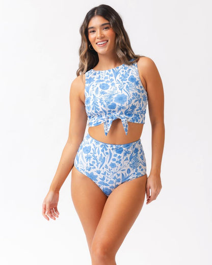 Woman wearing a blue floral bikini set on a white background
