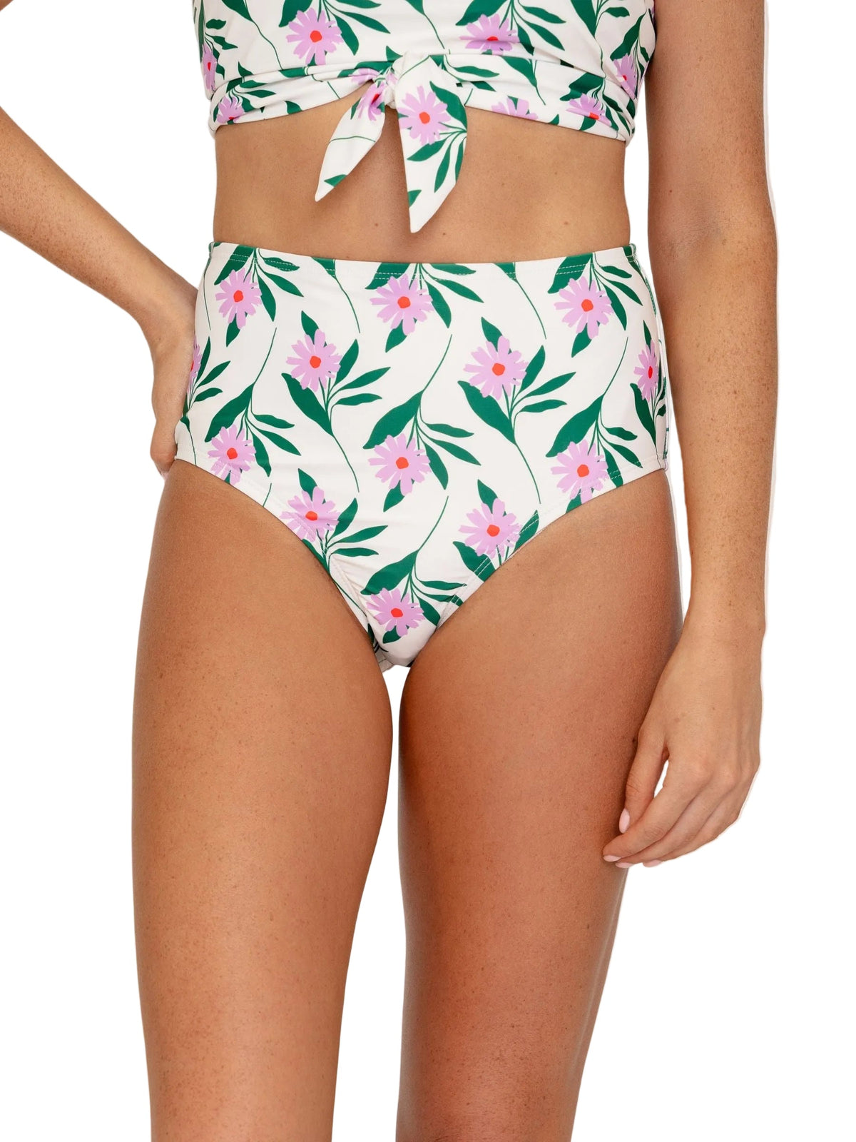 A model wearing a two-piece bikini set with a white background and a green, pink, and orange floral pattern. The set includes a tie-front crop top and high-waisted bottoms, shown against a plain white background.