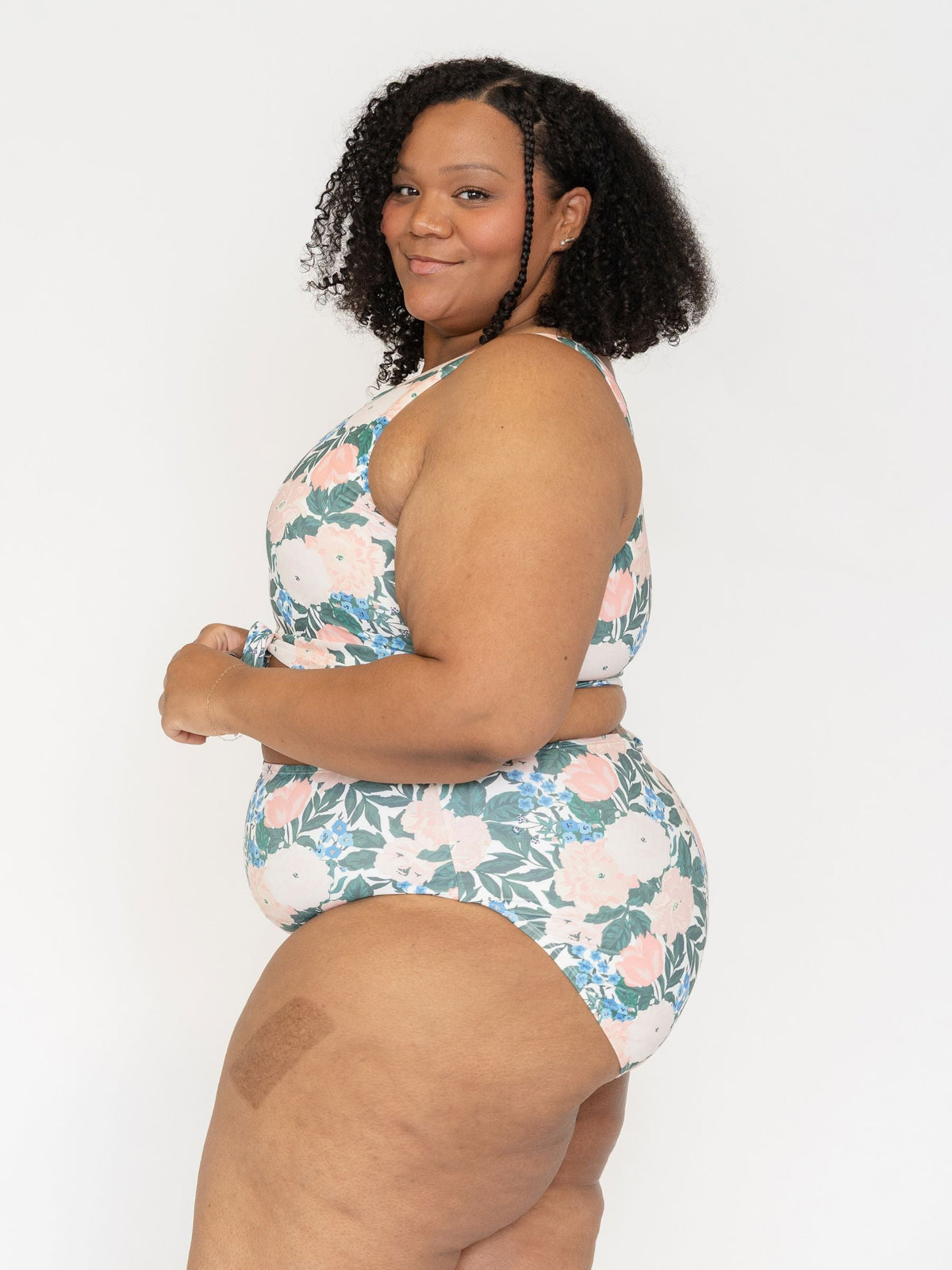 Woman wearing a floral swimsuit against a white background