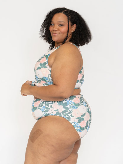 Woman wearing a floral swimsuit against a white background