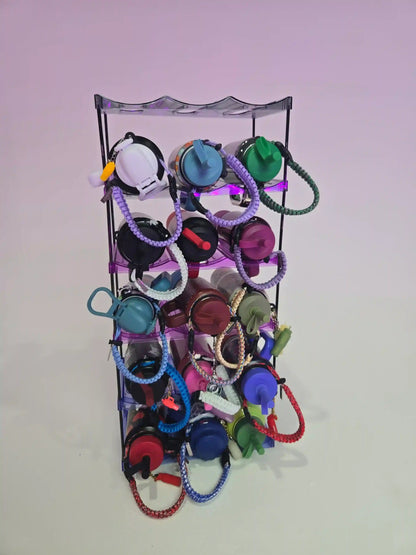 Metallic keychain display rack with various colorful keychains on a light purple background