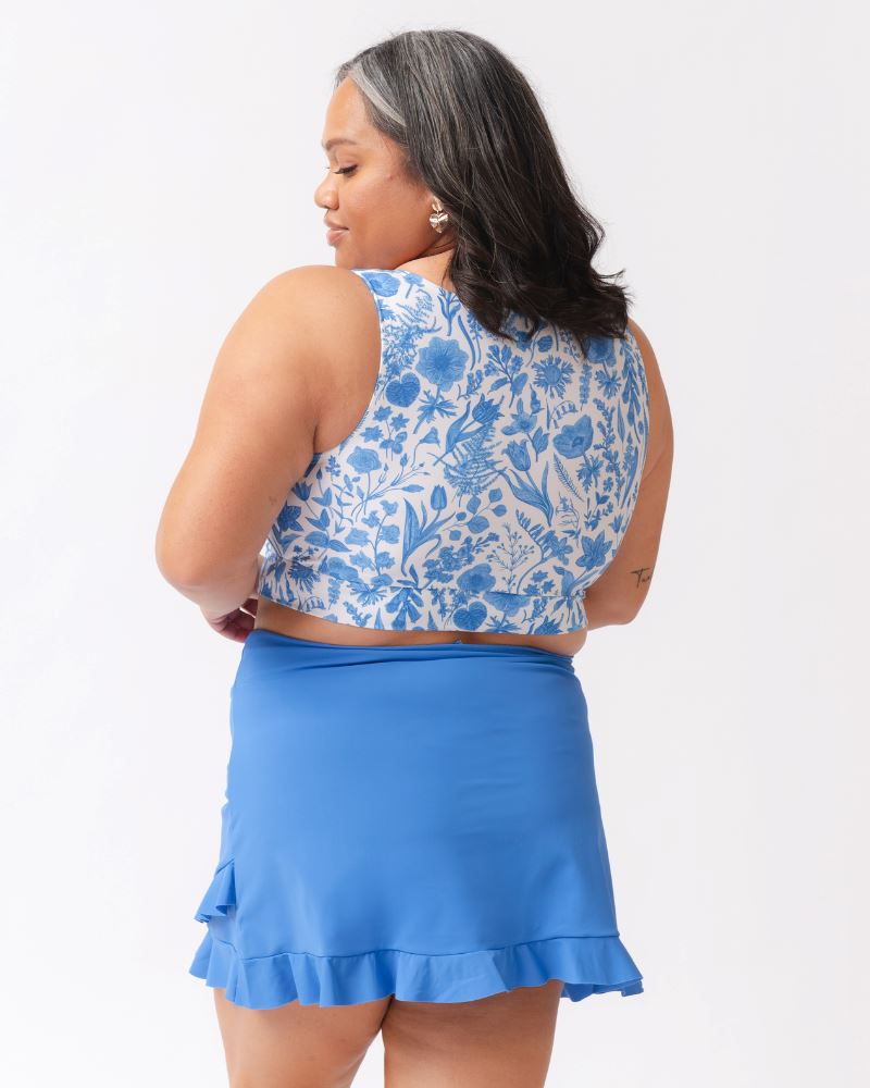 Woman wearing a blue floral top and matching skirt on a white background