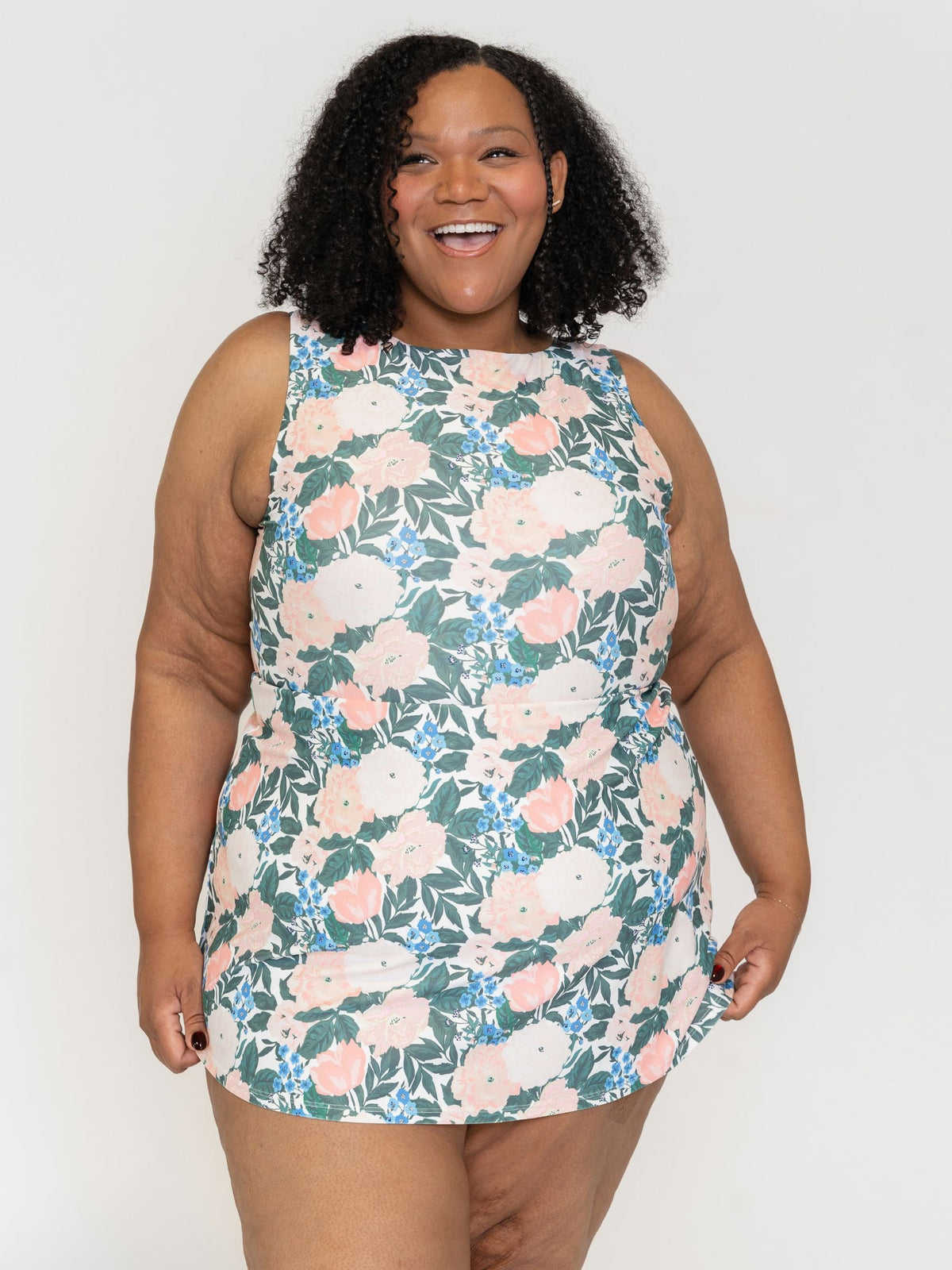 Woman wearing a floral dress against a plain background