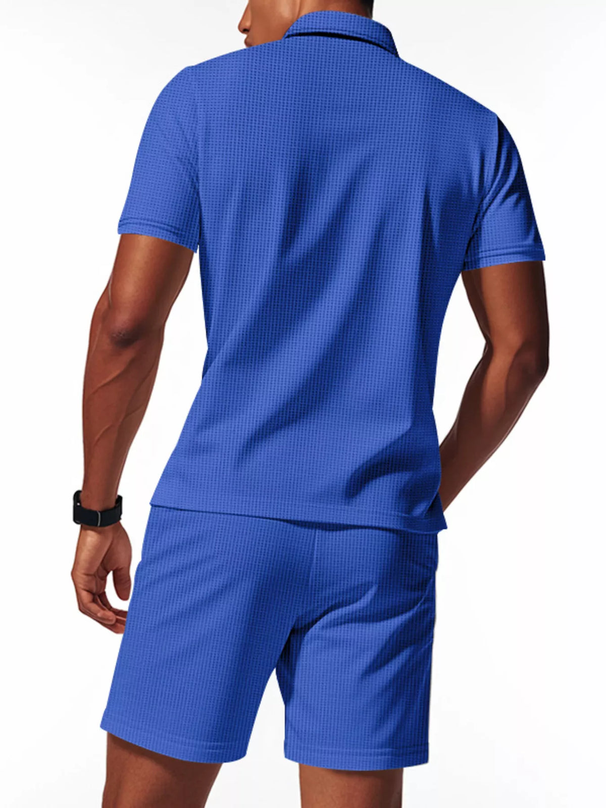 Person wearing a blue textured polo shirt and shorts set on a white background