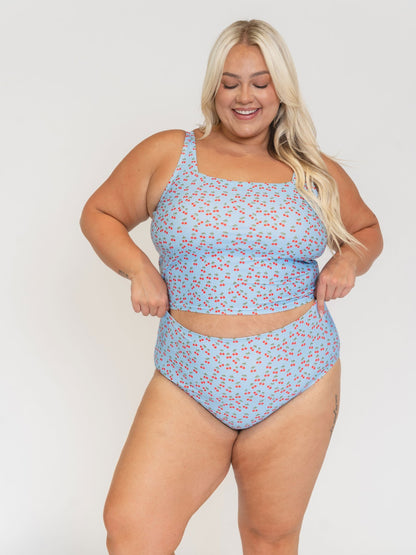 Woman wearing a blue floral swimsuit against a white background