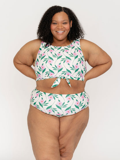 Woman wearing a floral two-piece swimsuit on a white background