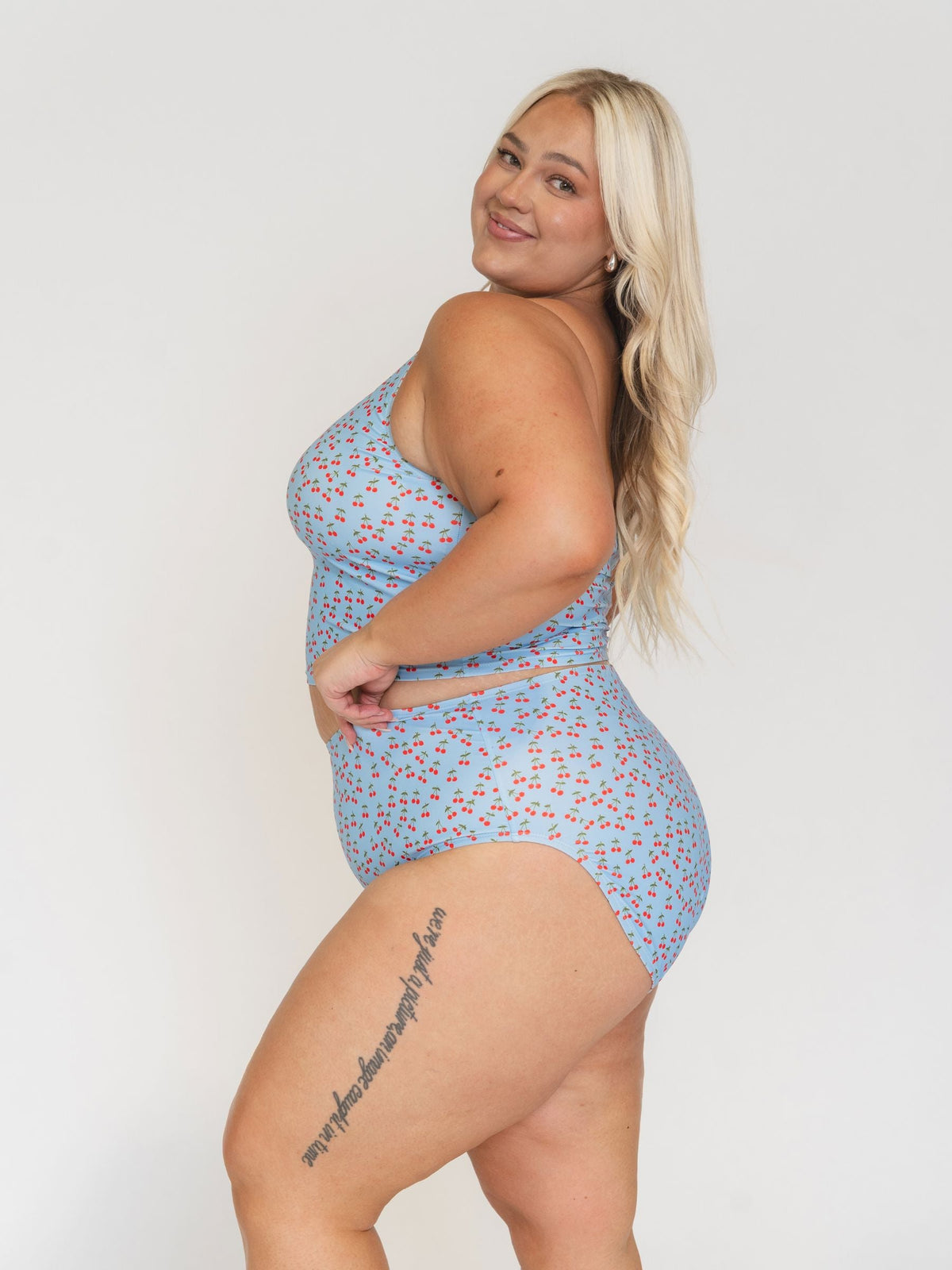 Woman wearing a blue floral swimsuit against a white background