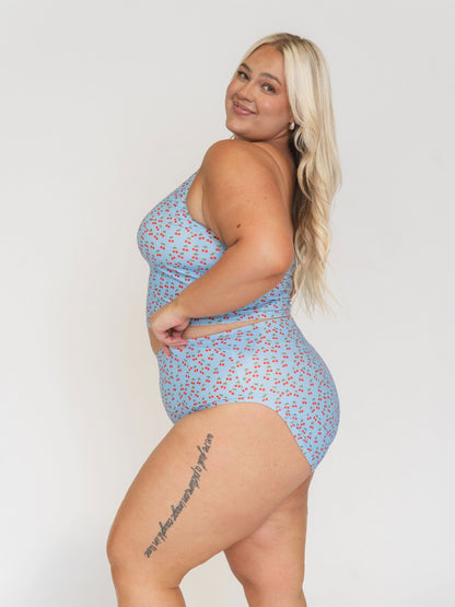 Woman wearing a blue floral swimsuit against a white background