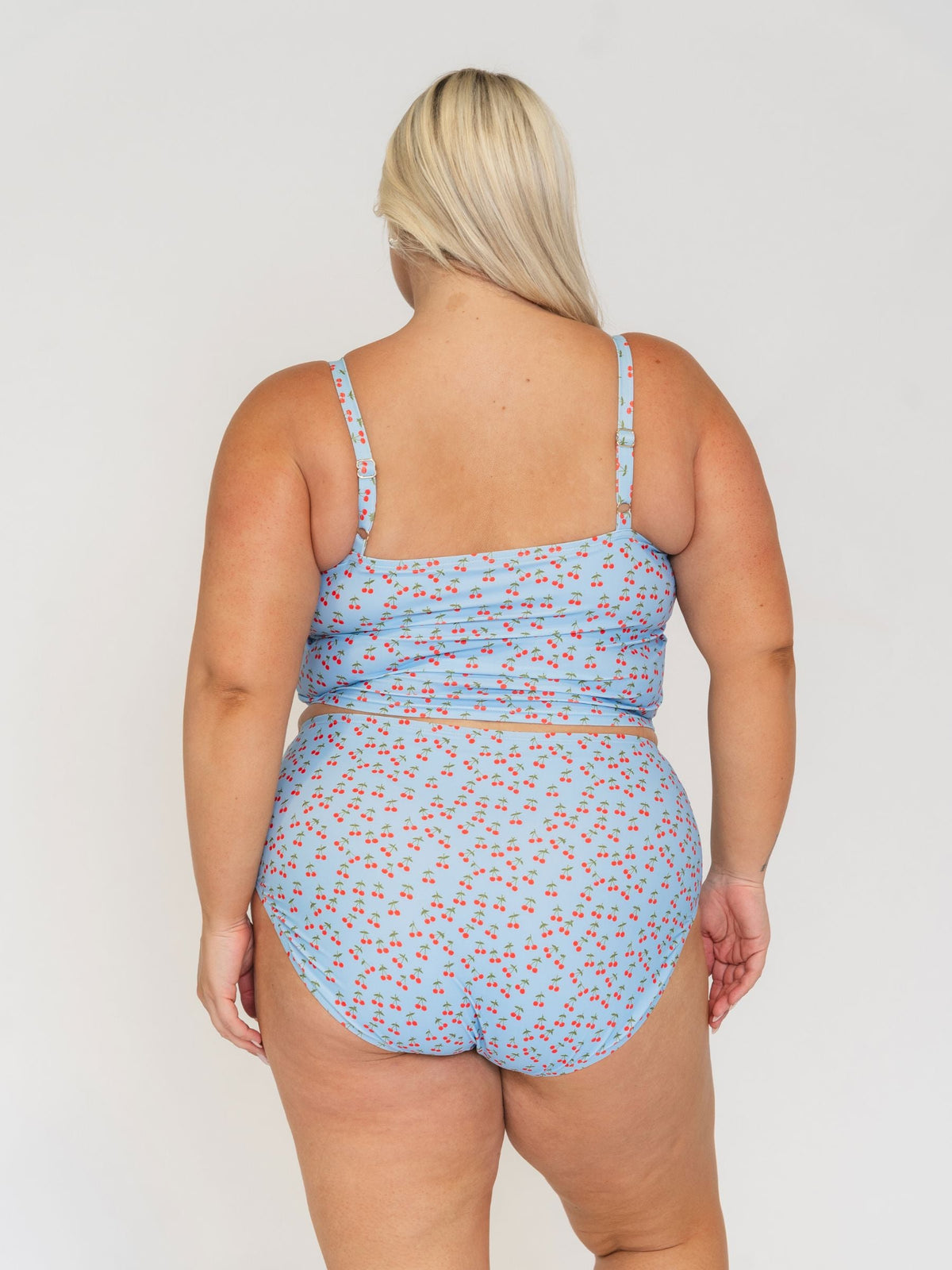 Woman wearing a blue floral swimsuit against a white background