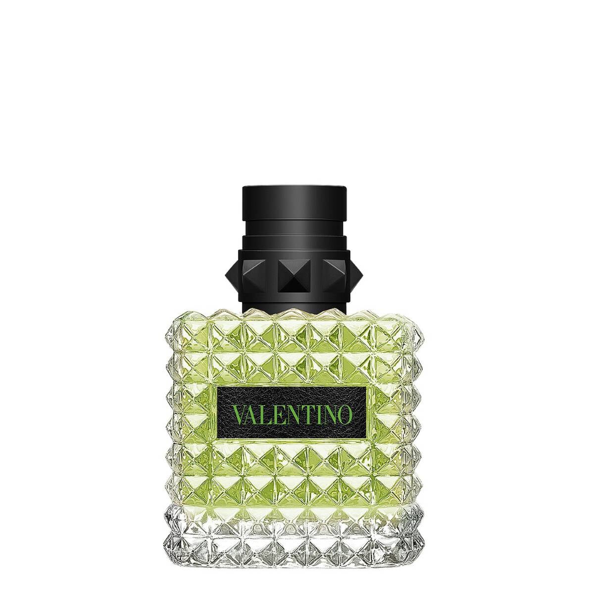 A bottle of Valentino fragrance with a textured, faceted clear glass body showing light green liquid inside, a black cap with a geometric design, and a black label with green 'VALENTINO' text, set against a plain white background.