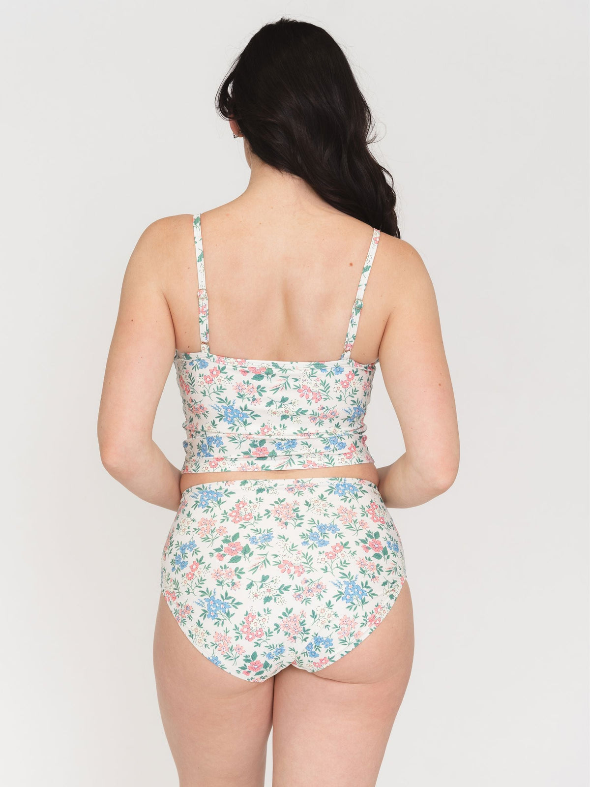Woman wearing a floral two-piece swimsuit on a white background