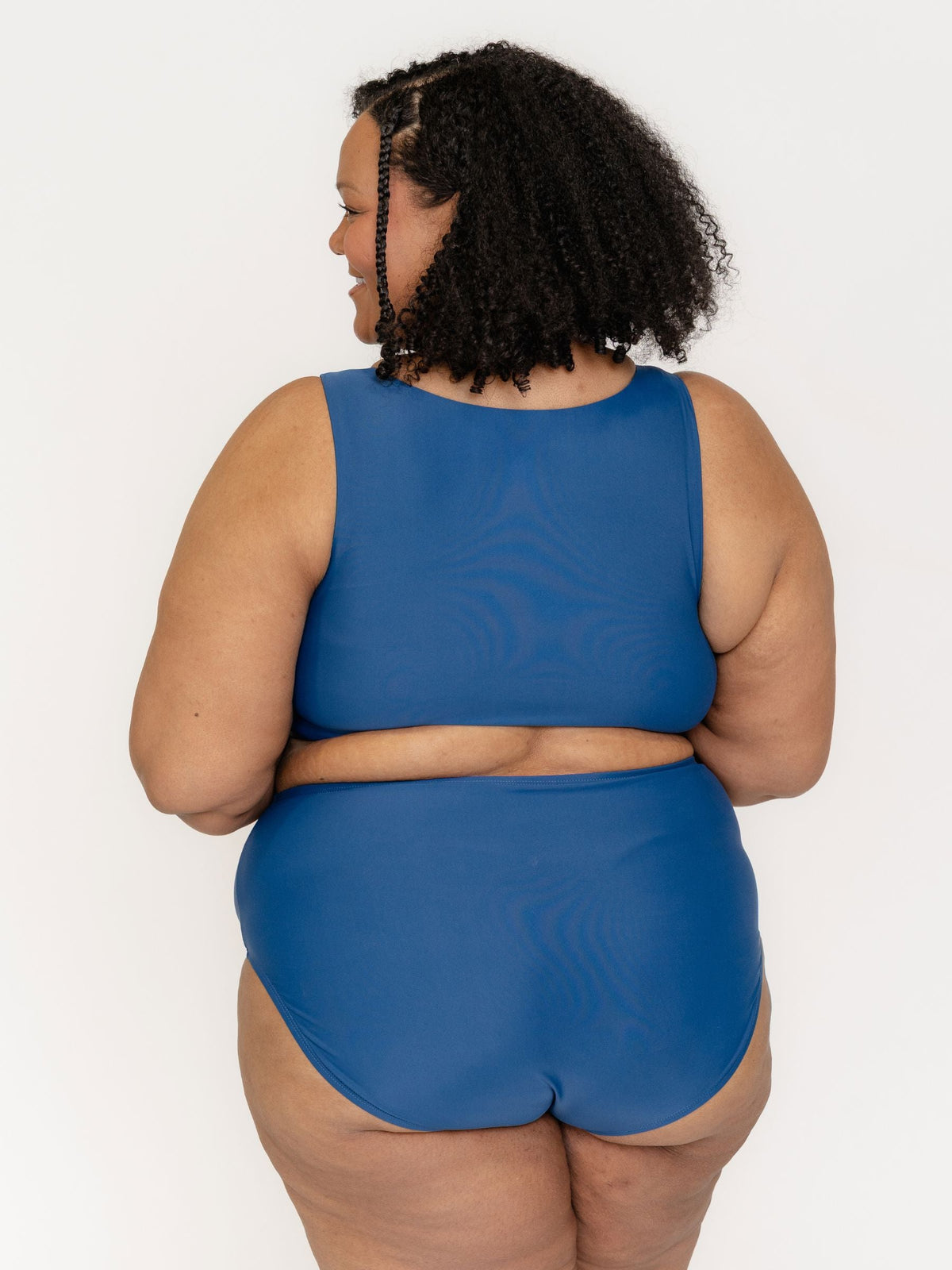 Person wearing a blue swimsuit against a white background