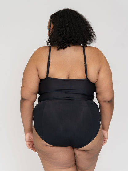 Person wearing a black swimsuit against a white background