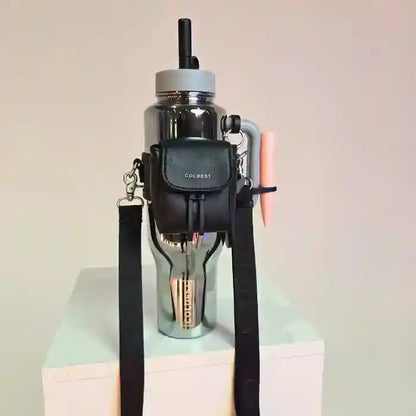 Black water bottle holder with a water bottle on a light pink surface