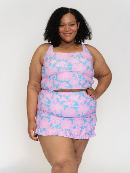 Woman wearing a pink and blue patterned outfit on a white background