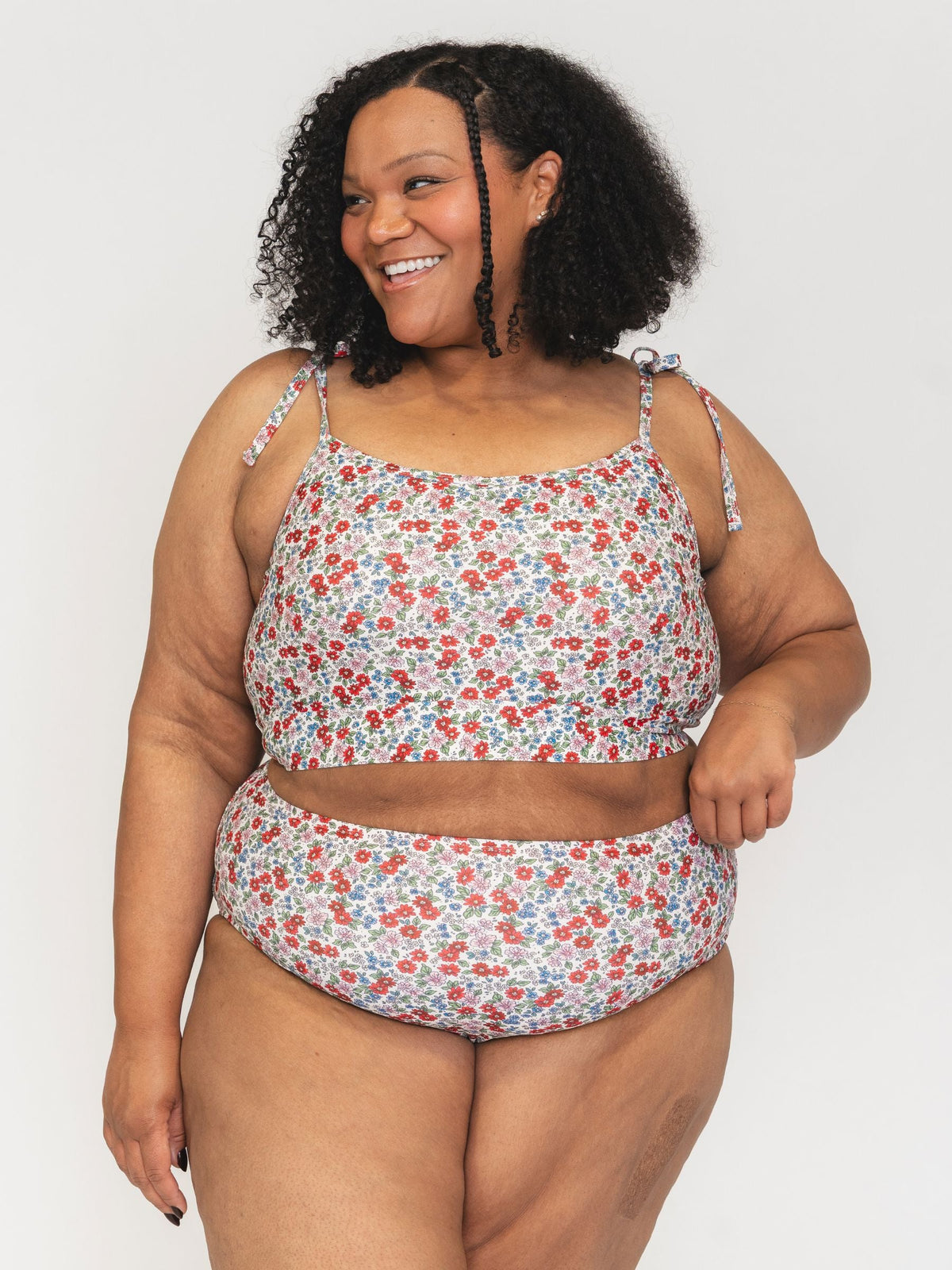 Woman wearing a floral two-piece swimsuit on a white background