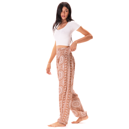 Woman wearing a white top and patterned pants on a white background