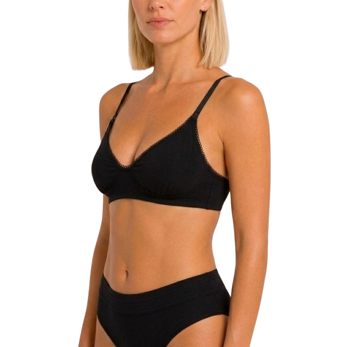 A woman wearing a black bralette with thin straps and a matching black bikini bottom, shown against a plain white studio background.