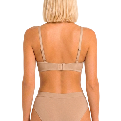 Rear view of a model wearing a beige seamless underwire bra and matching high-waisted briefs against a white background.