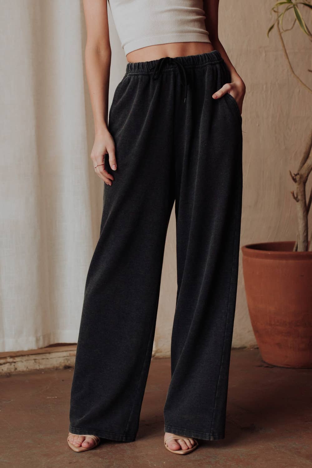 Person wearing black wide-leg pants with a neutral background