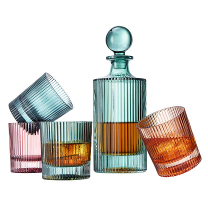 Set of colorful glass tumblers and a decanter on a white background