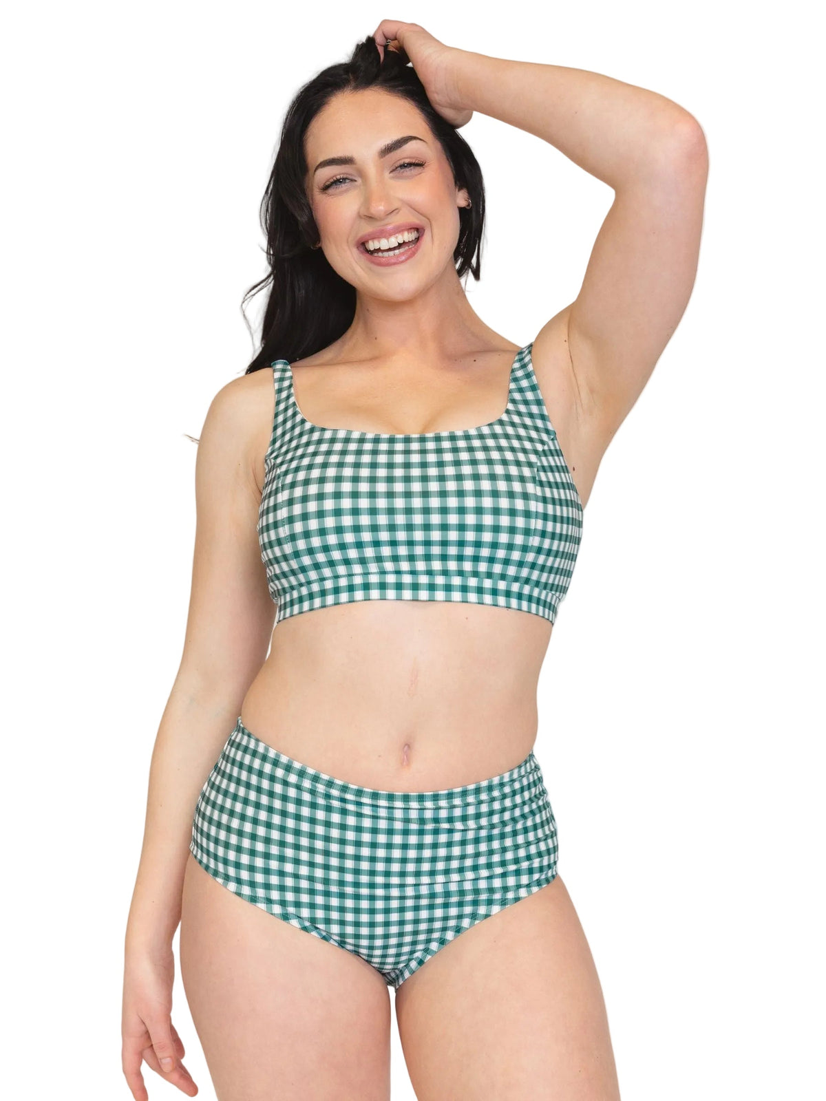 A woman modeling a two-piece bikini with a green and white gingham check pattern against a solid white background.